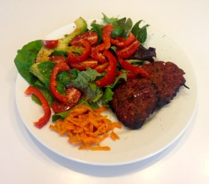 Healthy lamb burger patty with salad and fermented carrot kraut